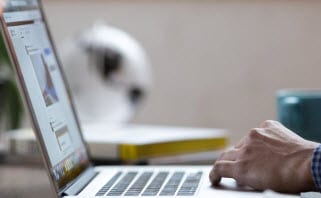 Contact us image depicting a set of hands moving on a laptop's keyboard